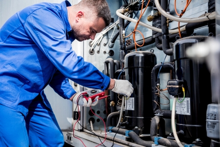 Electrician inspecting an industrial electrical panel in a New York City warehouse